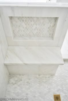 a bathroom with white marble tile and gold grouting