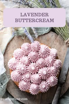 lavender buttercream frosting on top of a wooden cutting board next to flowers