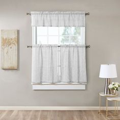 a living room scene with focus on the window curtain and chair in the foreground