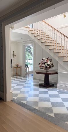 an entry way with a table and stairs in the background, leading to another room