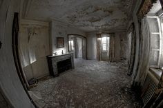 an old room with peeling paint on the ceiling and windows in the wall is seen through a fish - eye lens