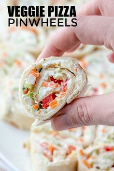 vegetable pizza pinwheels on a plate being held up by someone's hand