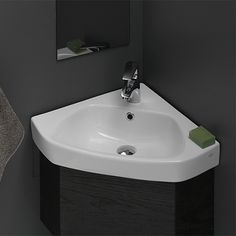 a white sink sitting next to a mirror in a bathroom under a faucet