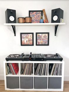 a record player is sitting on top of a shelf with some records and other musical equipment