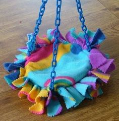 a multicolored handbag hanging from a chain on a wooden floor with wood floors in the background