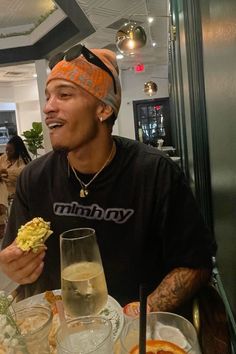 a man sitting at a table with food in front of him and looking up to the ceiling