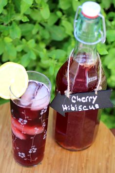 two glasses filled with liquid sitting on top of a wooden table