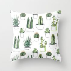 a white pillow with green cactuses and succulents on the front side