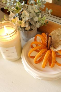 an orange peel on a plate next to a candle