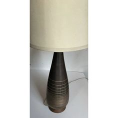 a lamp that is on top of a table with a white cloth shade over it