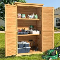 a garden shed with the door open and tools in it's storage compartment next to a lawn mower