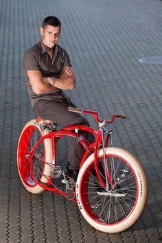 a man sitting on top of a red bike