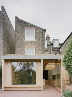 an open air room in front of a brick building with windows on the roof and side walls