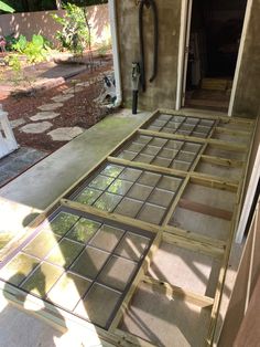 the inside of a house that is being built with wood framing and glass panels on the floor