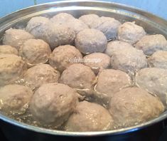 meatballs are being cooked in a pot on the stove top, ready to be eaten