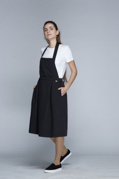 -Apron Wrap Dress ONA. Joint project of the UGi code team and designer Ieva Ševiakovaitė. A collection of clothing designed by the fashion designer under the UGi - UNIFORM by IEVA label. We are delighted to be able to offer you and your team products designed and made in Lithuania with love and care, down to the very last seam. -Base colour of the model is black. -One size fits all.  -Composition - 78% polyester, 17% viscose, 5% spandex. -The density of fabric - 195 g/m². -Designed and manufactured in Lithuania. Spring Black Pinafore Dress For Work, Black Spring Pinafore Dress For Work, Modern Black Dresses For Work, Black Workwear Dress With Pockets, Black Dress With Pockets For Work, Handmade Aprons, Uniform Fashion, Apron Dress, Office Outfits