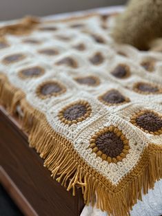 a crocheted blanket on top of a wooden bed