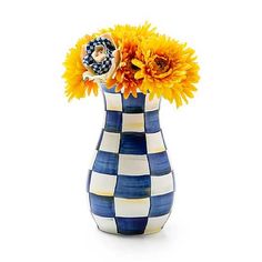 a blue and white checkered vase with sunflowers in it on a white background