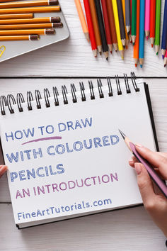 someone is drawing with colored pencils on a notebook