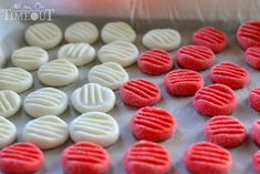 red and white cookies are on a baking sheet