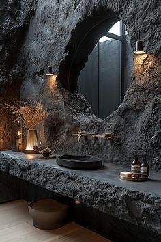 a bathroom with stone walls and lights on the counter, along with a bowl shaped sink