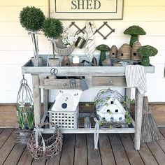 a table with potted plants on top of it next to a sign that says, the garden shed