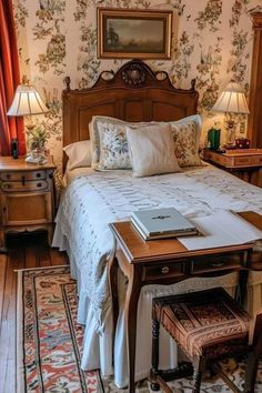 a bed sitting in a bedroom next to a table with a laptop on top of it