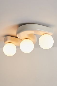 three round lights are hanging from the ceiling in a room with white walls and flooring