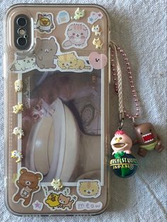 an iphone case with stickers on it and a keychain attached to the phone