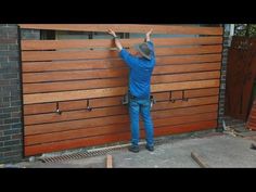 a man is working on a wooden fence