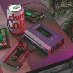 a table topped with cassettes and a can of soda