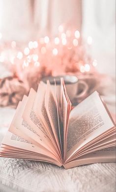 an open book sitting on top of a bed