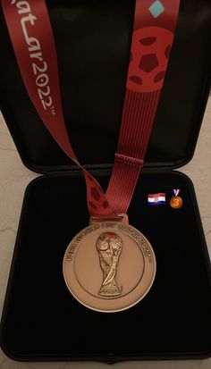 a gold medal with a red ribbon around it