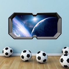 three soccer balls sitting in front of a window with the view of earth from space