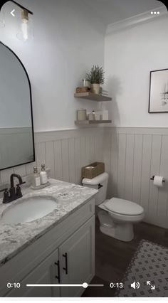 a bathroom with a sink, toilet and shelves on the wall above it's mirror