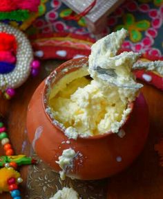 a bowl filled with mashed potatoes sitting on top of a wooden table next to other items