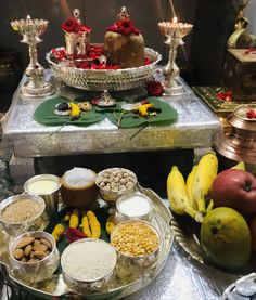 an assortment of food is displayed on a silver platter in front of other dishes