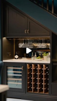 a wine rack under the stairs in a home bar with lots of bottles and glasses on it