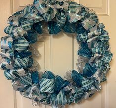 a blue and white wreath hanging on the front door