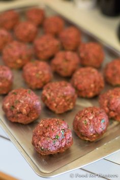 raw meatballs on a baking sheet ready to be baked in the oven or used as an appetizer