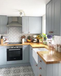 a kitchen with grey cabinets and wooden counter tops