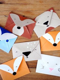 some paper animals that are on top of a wooden table with one animal cut out