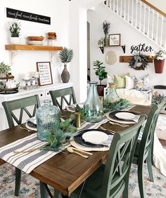 the dining room table is set with plates and place settings