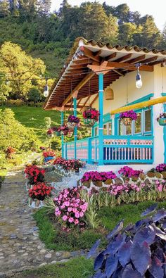 a blue and white house surrounded by flowers