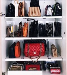 a closet filled with lots of purses and handbags on top of white shelves