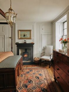 a bedroom with a bed, chair and fireplace in it