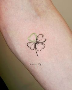 a four leaf clover tattoo on the arm