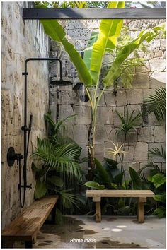 an outdoor shower with plants and a bench in the middle, surrounded by stone walls