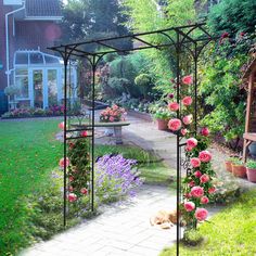 a dog laying on the ground in front of a garden with pink flowers and potted plants