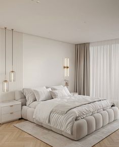 a large white bed sitting in the middle of a bedroom next to a tall window